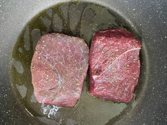 surovy steak v panvici