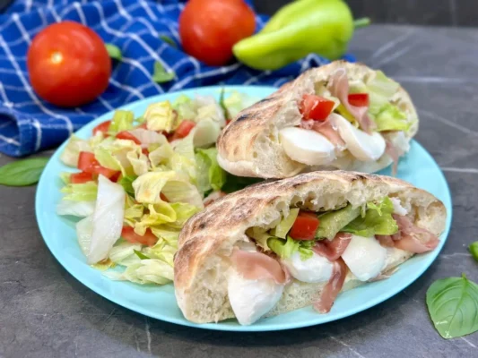 Pita plnená sušenou šunkou a mozzarellou s talianským dresingom a šalátom
